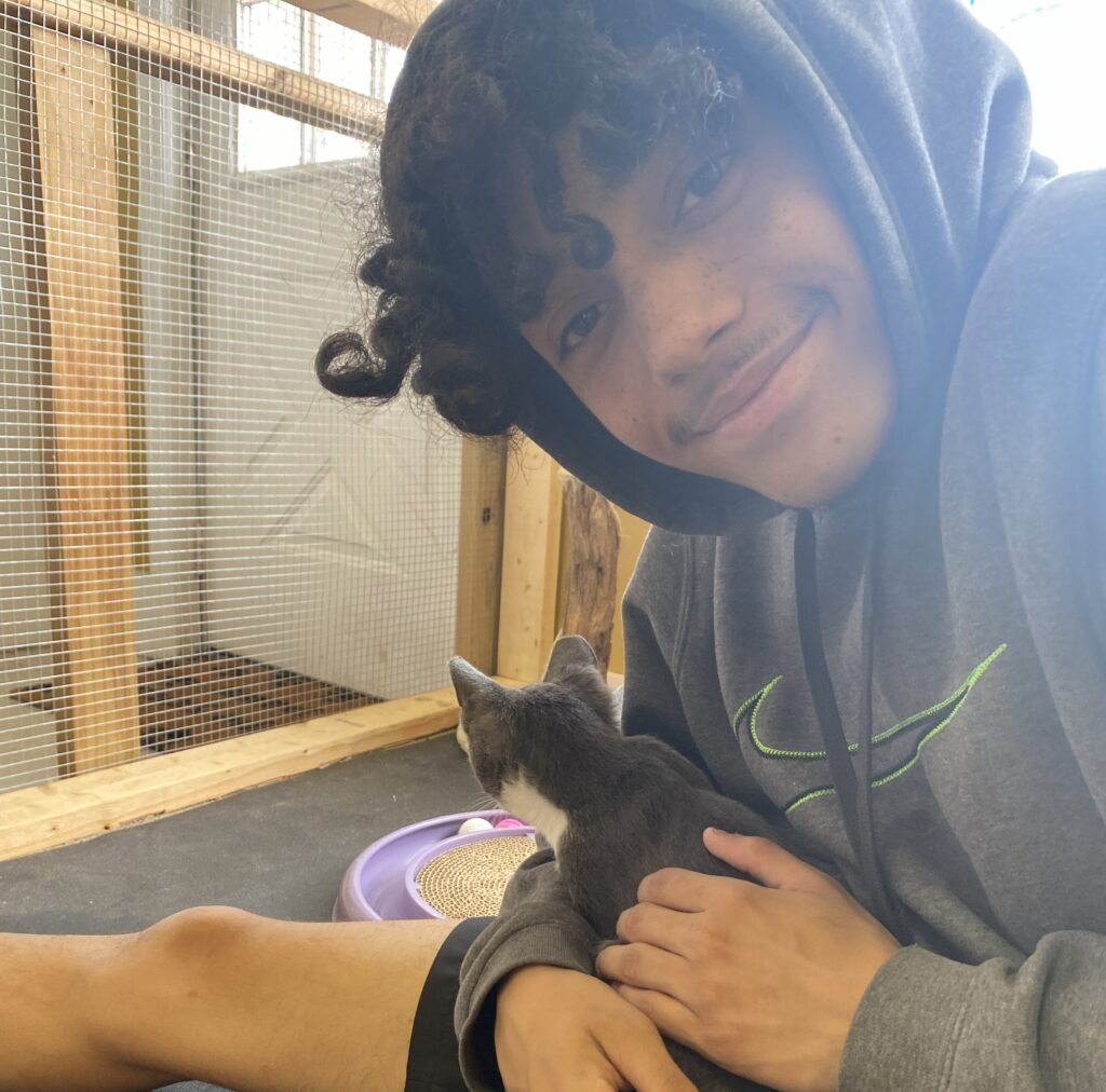 Donor hero, Dewey Waters, holds a cat and smiles at the camera.