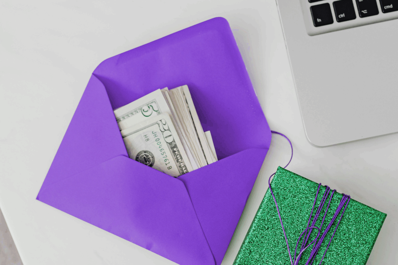 A purple envelope has cash inside it to symbolize making a contribution.