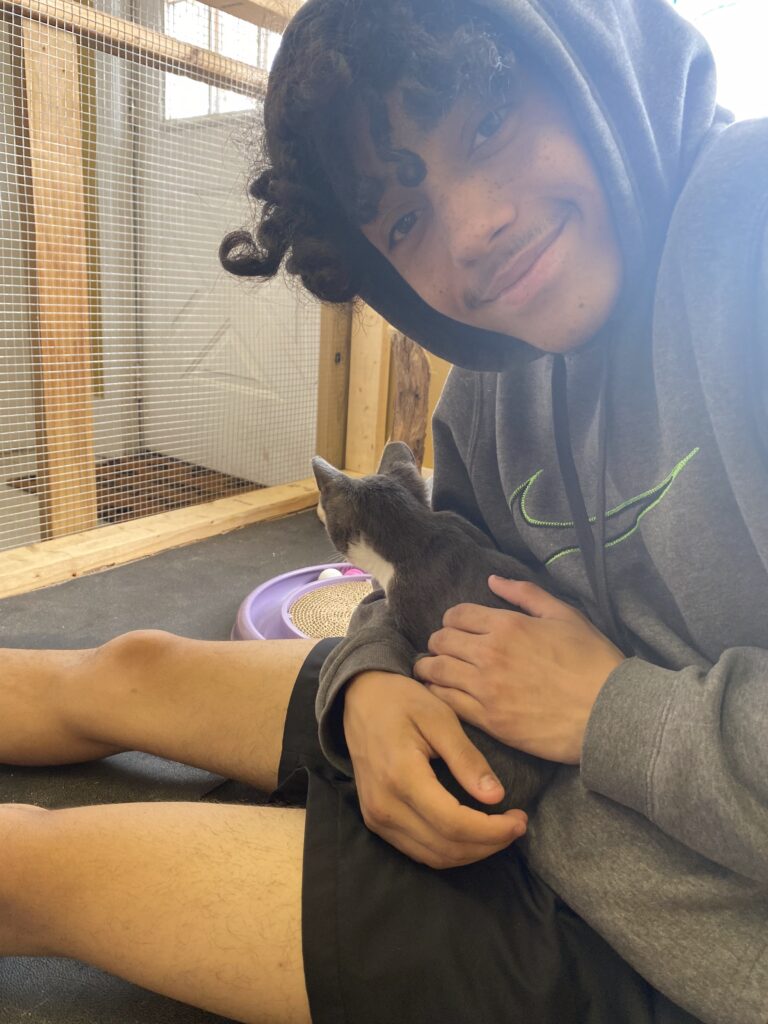Dewey Waters, a donor hero smiles and holds a cat.
