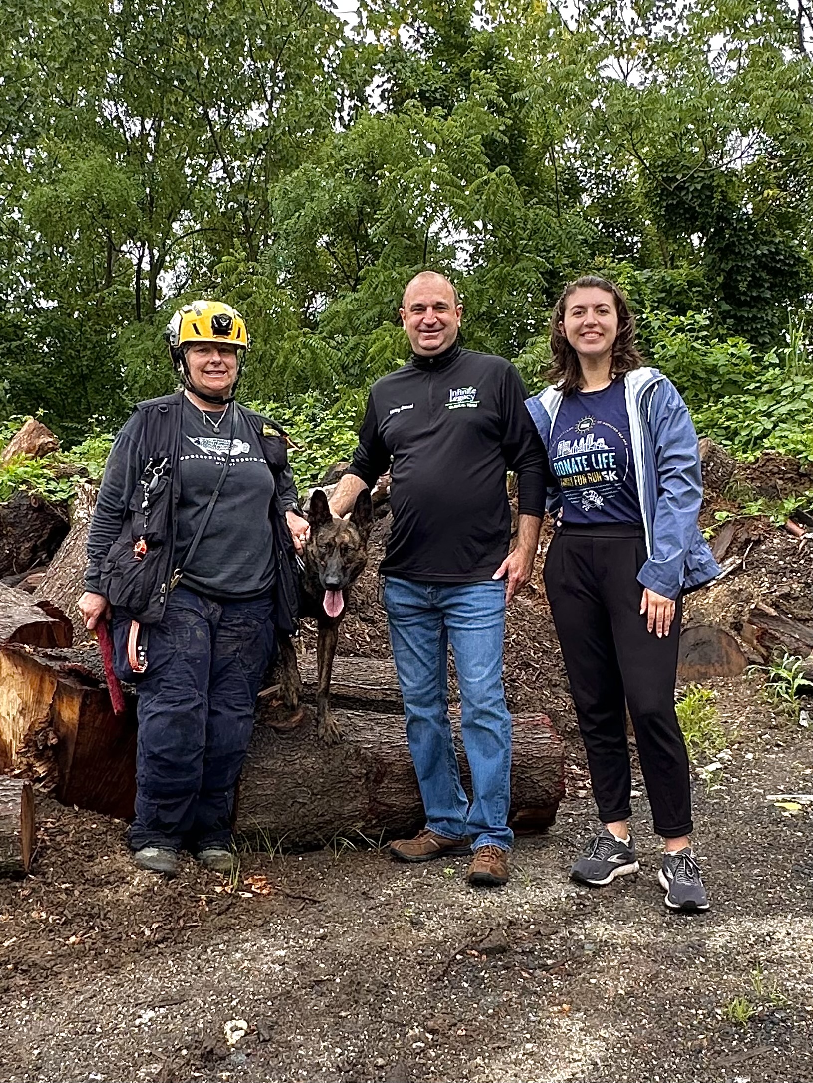 Search & Rescue Assist, Inc. (SARA) trainers stand with a K9 and Infinite Legacy's Digital Media Coordinator, Emma Sampson at the simulated disaster scenario.