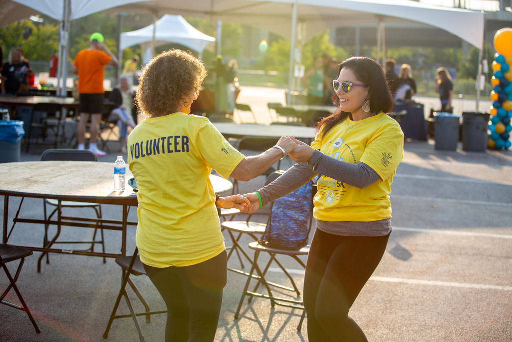 Two volunteers dance together at Infinite Legacy's Annual Donate Life Family Fun Run to honor organ, eye and tissue donors.