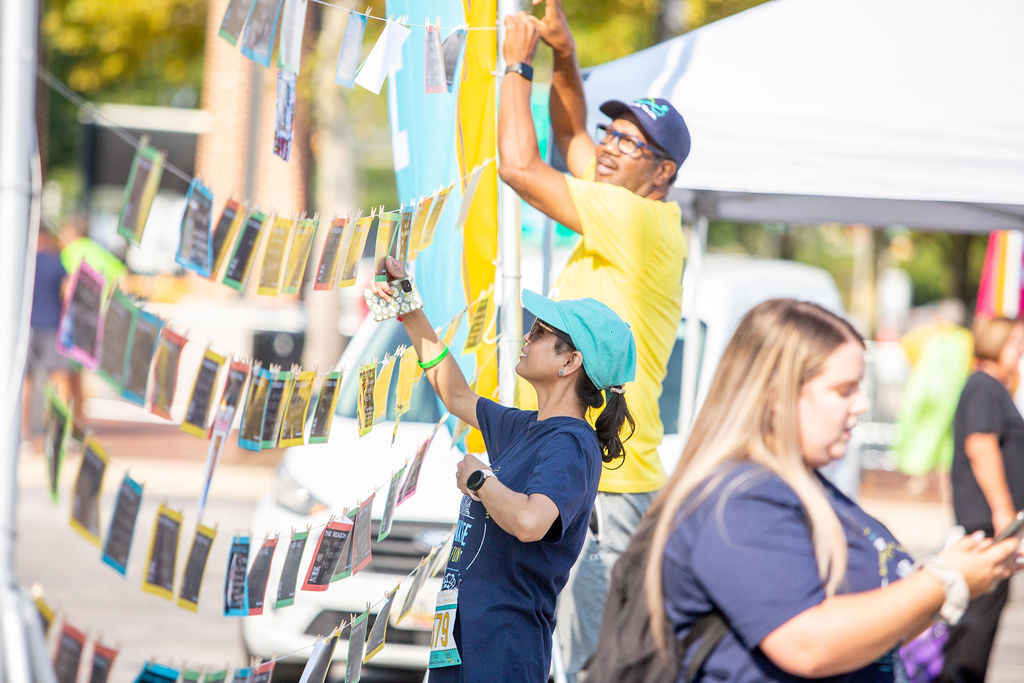 Infinite Legacy staff hang Why We Walk signs to encourage participants to share why they walk or run at the Annual Donate Life Family Fun Run.