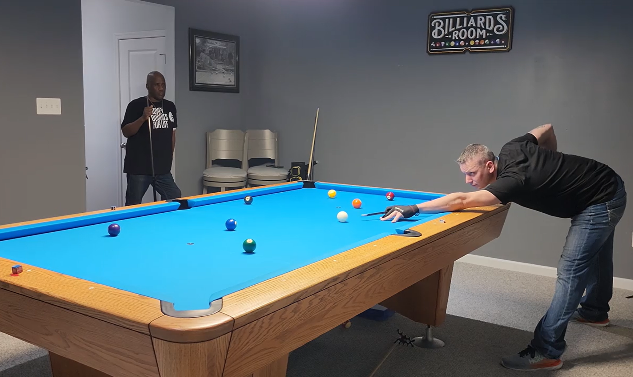 James and Russ playing pool, wearing Kidney Buddies for Life t shirts.