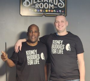 James Harris and Russ Redhead wrap their arms around each other wearing Kidney Buddies for Life t shirts after playing a game of pool.