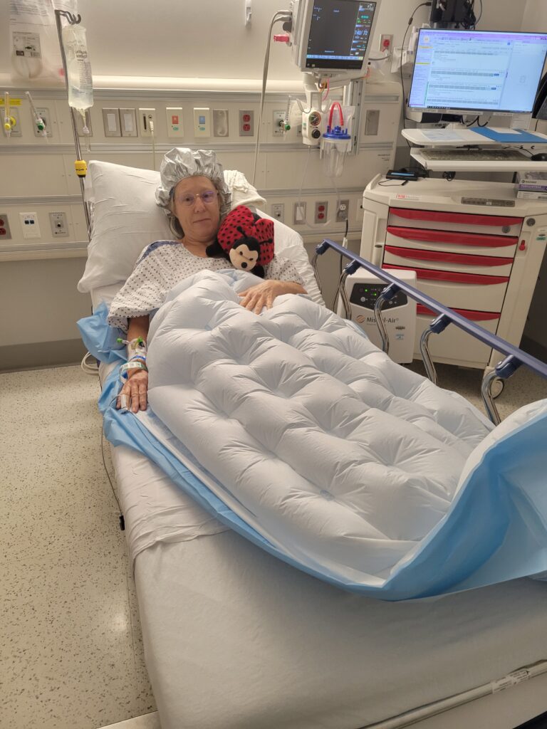Susan is in the hospital holding her daughters ladybug stuffed animal in preparation to donate a kidney and save a life like Kimberly.