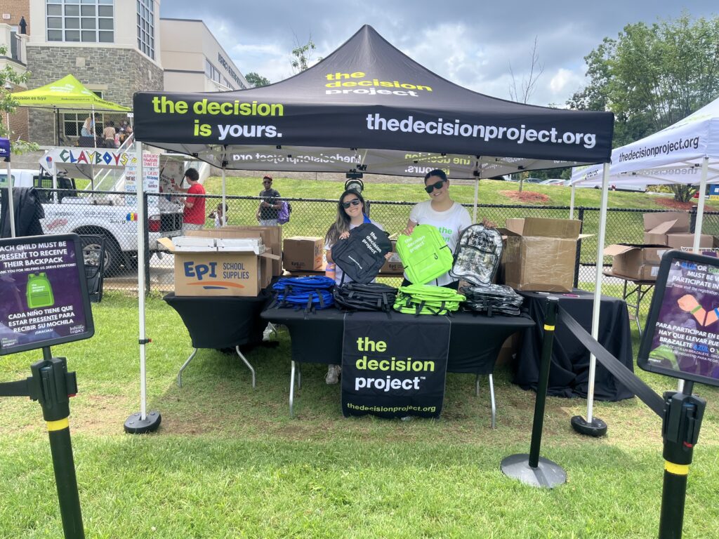 Two Infinite Legacy team members handing out The Decision Project backpacks at a Block Party in Maryland.