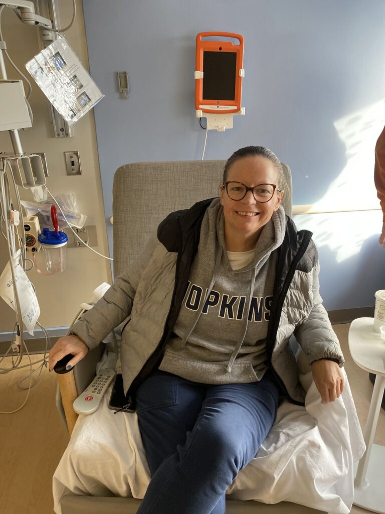 Kristin is at the hospital wearing a Hopkins sweatshirt getting ready to go home during the holidays after her successful kidney transplant.