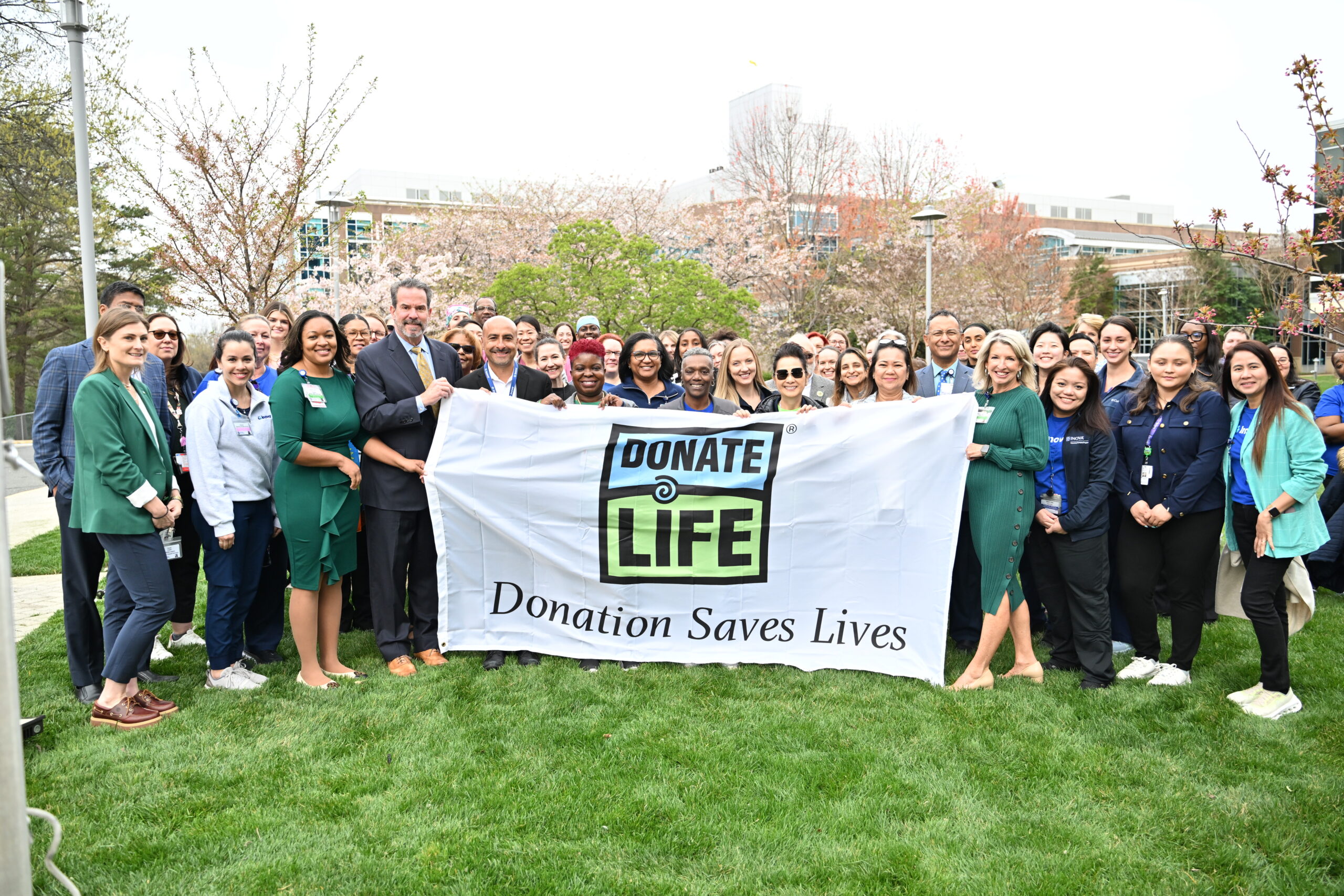 Infinite Legacy staff and hospital partners hold a Donate Life flag to honor organ, eye and tissue donors.