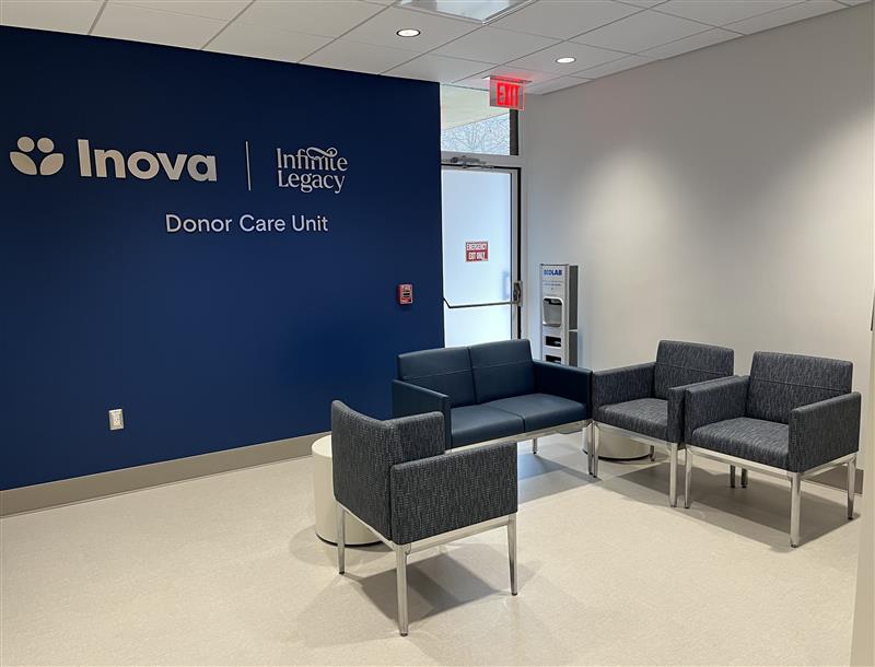 Waiting area at the Donor Care Unit: blue wall with Inova and Infinite Legacy logos; blue sofa with four gray chairs around a small white table.