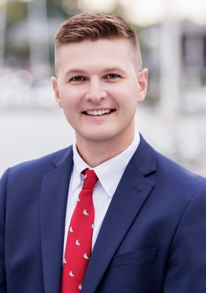 Heart recipient Brandon Kerrigan poses for a professional headshot in a suit.