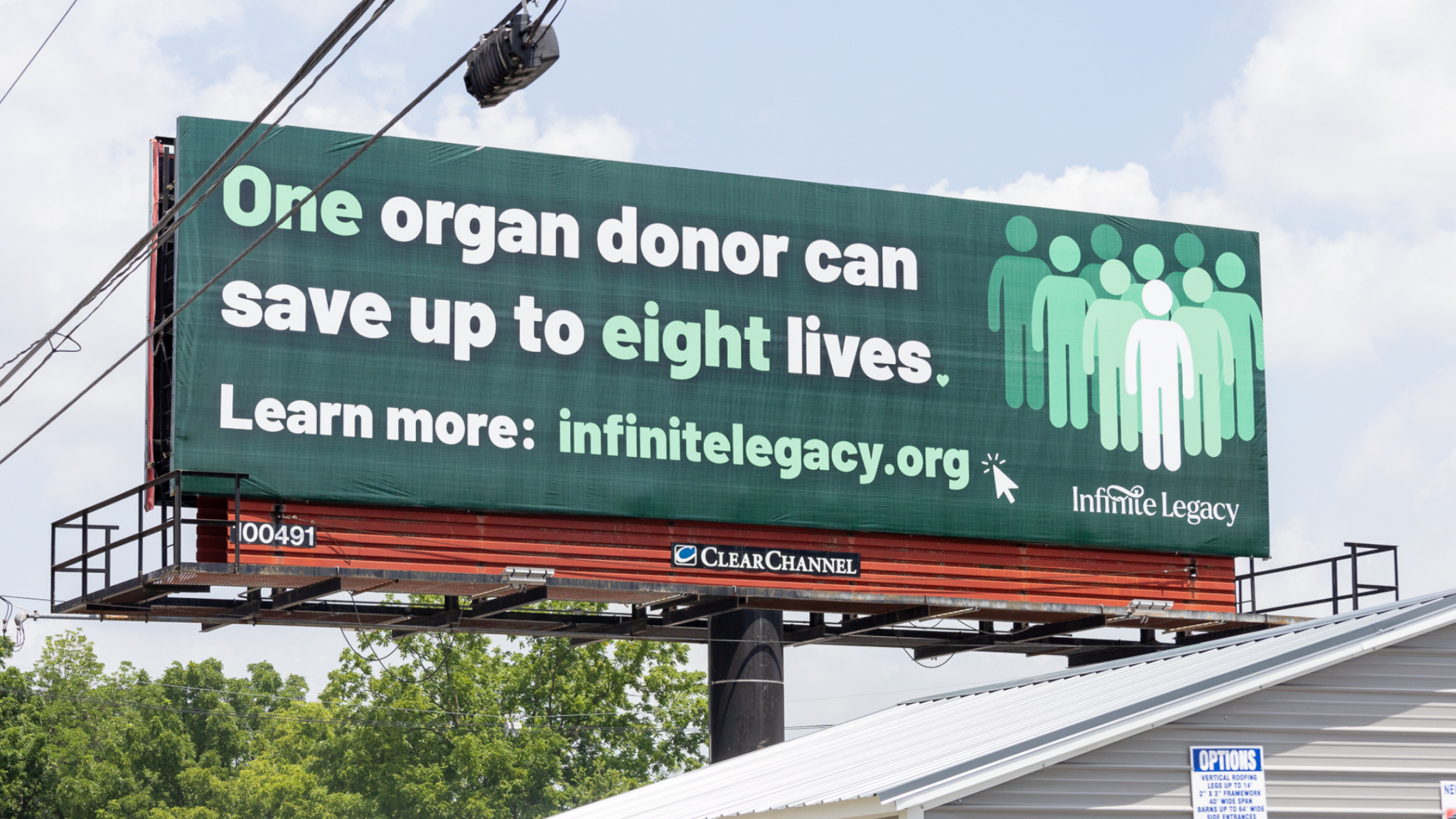 Billboard promoting organ donation: 'One organ donor can save up to eight lives' with a group-icon graphic and infinitlegacy.org URL.